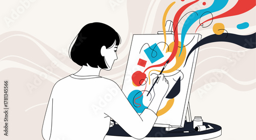 Female artist with short black hair painting an abstract and colorful artwork on a canvas using a brush in a creative studio setting.