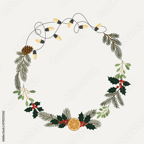 Świąteczna ramka wianek z gałązkami jodły, sosny, ostrokrzewem, jemiołą, plastrem pomarańczy, szyszką i lampkami choinkowymi.