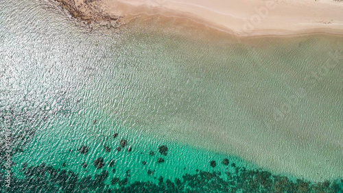 Aerial view of Coral Bay and beach in Western Australia with turquoise ocean and white sand