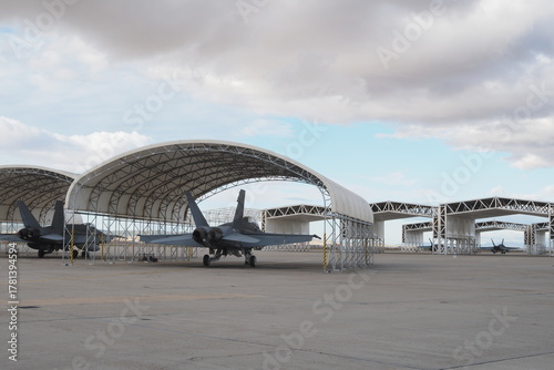 Fotografie Several twin-engine multirole fighters aligned under canopy shelters at military