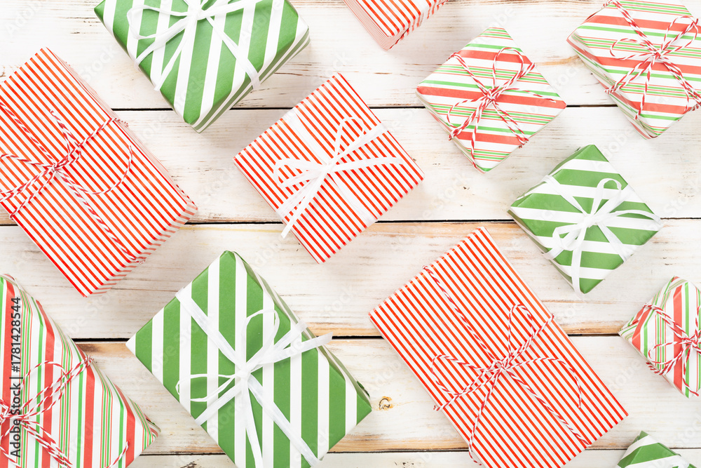 Fototapeta premium Many striped Christmas gift boxes on wooden background, top view