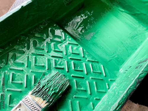 Photos Green paint filling textured tray with paintbrush soaking in vibrant color, ready for diy projects, home improvement or creative art and craft work