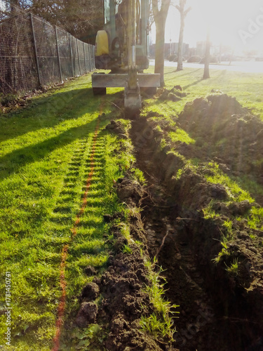 Excavator digging trench for underground installation