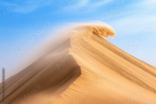 Fototapeta Naklejka Na Ścianę i Meble -  Wind blowing sand off the top of a sharp dune crest