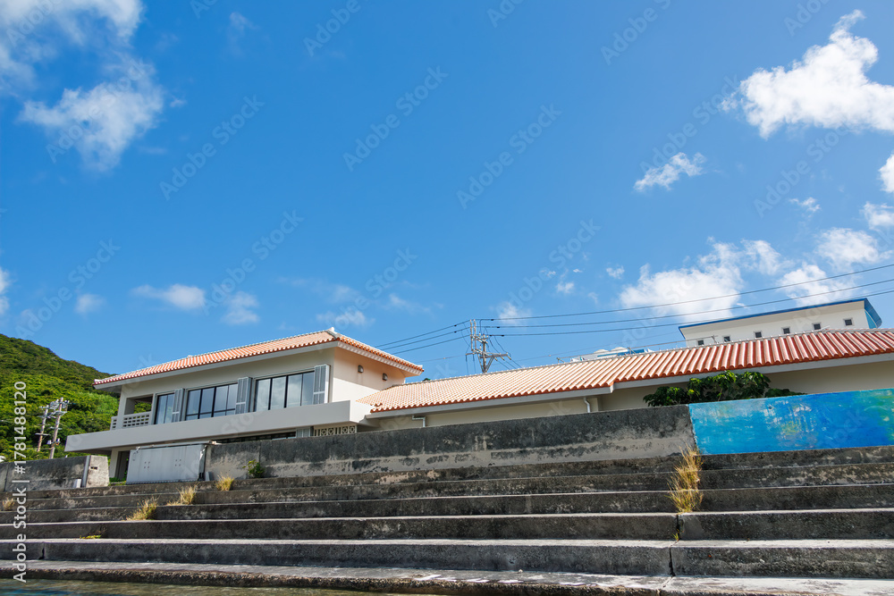 Fototapeta premium 座間味港の風景。 座間味島座間味港 沖縄県島尻郡慶良間諸島-2025 沖縄本島から40km西方にある諸島。 大小30以上の島々からなる島嶼群は全体が国立公園に指定されている。 珊瑚礁の海、白い砂浜、緑の山地は世界屈指の美しさ。 多くの貴重な動植物が生息している。 