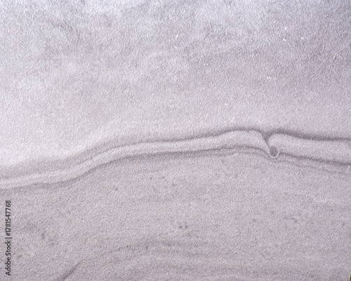 Gray marble, wavy natural stone pattern with inclusions, close-up.