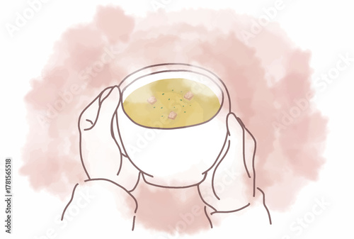 温かいコーンスープの入ったマグカップを持つ手
