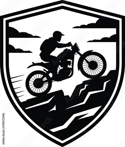 Motorcycle trials rider performing a stunt against a mountain shield silhouette
