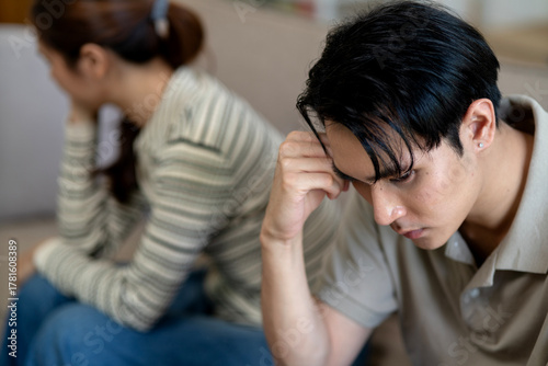 Asian adult couple facing relationship problems at home showing emotional stress and sadness during difficult conversation