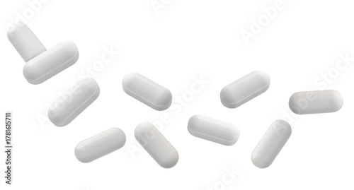 dramatic close-up photograph featuring nine individual white, bar-shaped pharmaceutical tablets scattered loosely and isolated against a stark transparent background.