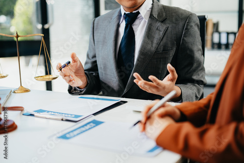 Lawyer consulting client with legal documents and scales of justice on desk. Concept of law, contract, consultation, and professional legal service.