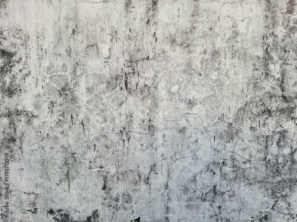 Fototapeta premium ​Old, distressed gray concrete wall background with cracks and grunge texture. Cement surface, weathered, aged, vintage, rough, dark, dirty, abstract backdrop.
