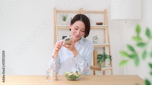 スマホで料理の写真を撮る女性