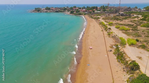 Side, Manavgat, Turkey. Ancient Agora and Roman amphitheater with crane, Temple of Tyche, colonnaded street, beach at archaeological site on sunny day. Aerial View