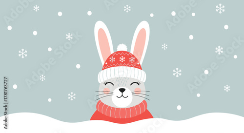 A cheerful gray bunny wearing a cozy red knitted hat and scarf peeks over a snowdrift, surrounded by falling snowflakes.