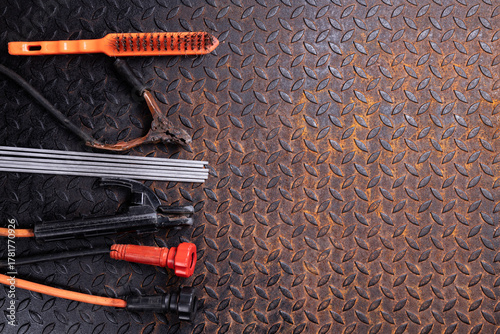 Welding tools arranged on a steel table in an industrial manufacturing plant, top view.