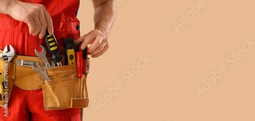 Wallpaper Mural Male worker wearing tools belt on beige background with space for text, closeup Torontodigital.ca