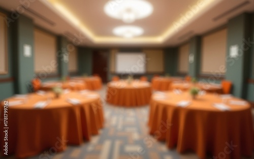 Blurred background of an elegant conference room featuring round tables with orange tablecloths and modern decor for professional gatherings. High quality