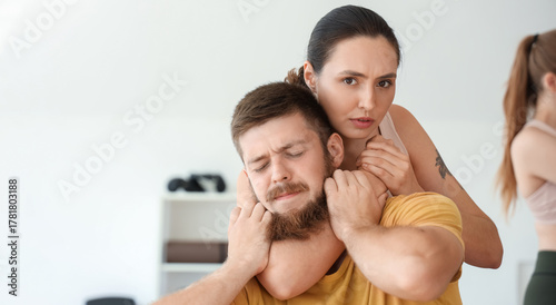 Tableau sur toile Young woman training at self defense courses in gym
