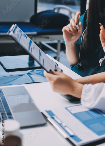 Group of doctors attending seminar in hospital lecture hall with senior physician giving medical presentation and professional training session on healthcare practices
