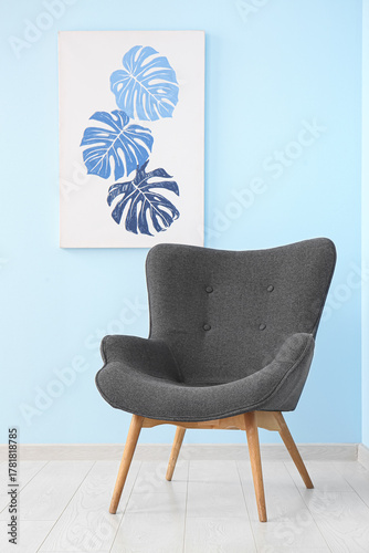 Grey armchair near blue wal...