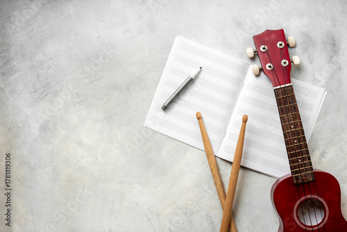 Wallpaper Mural Musical instruments - small guitar and drumsticks with music notebook, top view Torontodigital.ca