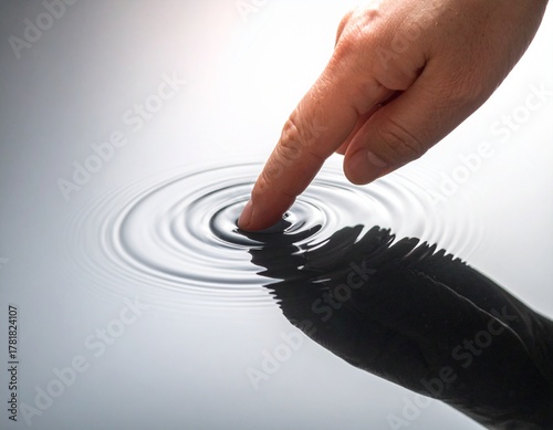 Macro Close-up Photography of a Fingertip Touching a Still Water Surface at the Moment the First Ripple Begins