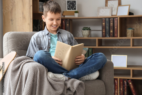 Teenage boy reading book on...
