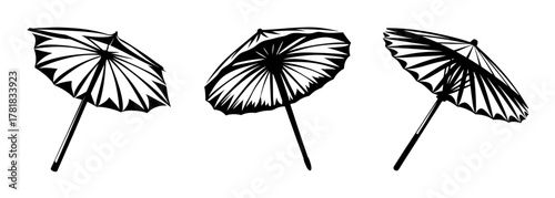 Three black and white cocktail paper umbrellas arranged in a row for tropical drinks and party decorations