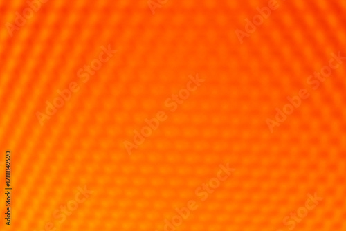 Orange yellow vibrant abstract background. The blurred geometric hexagonal pattern creates a warm, intense, and dynamic texture