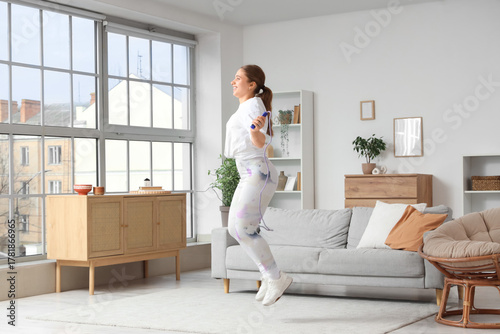 Sporty young woman jumping ...