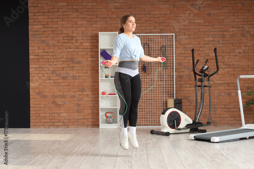 Sporty young woman jumping ...