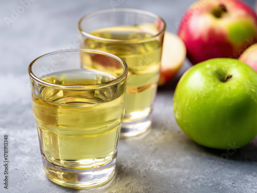 Fresh Green Apple Juice in Glasses with Apples on Grey Background