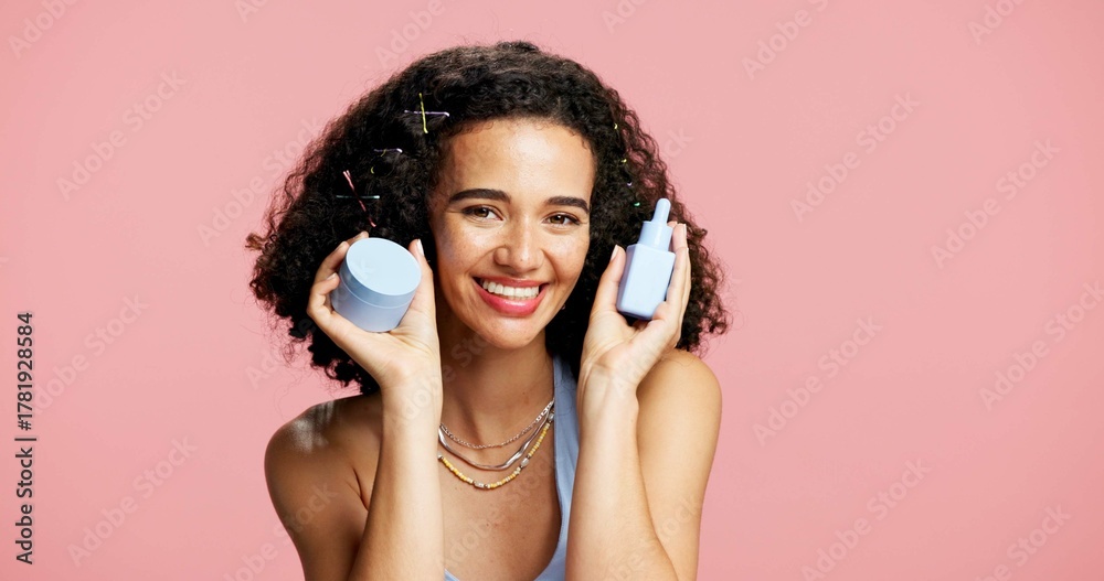 Fototapeta premium Beauty, portrait and product with happy woman in studio for cream or lotion recommendation. Container, moisturizer and skincare with excited model on mockup space or pink background for cosmetics