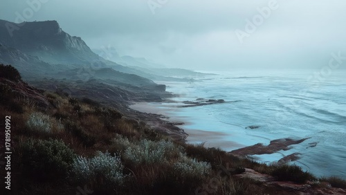 Misty coastal scene with rugged cliffs, a calm blue sea, and scrubby vegetation along a rocky shoreline. Concept Misty coastal scene, Rugged cliffs, Calm blue sea, Scrubby vegetation, Rocky shoreline