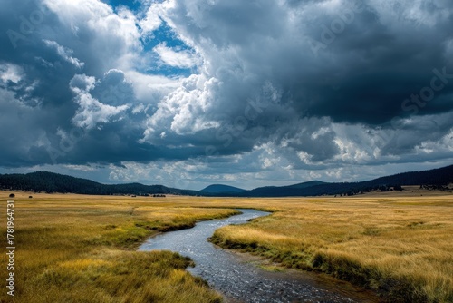 Stream Flowing Through Lush Grasslands Beneath Dramatic Storm Clouds in Valles Caldera National Preserve, New Mexico