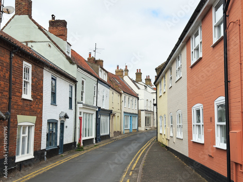 A peaceful town street of typical old painted brick, period terraced houses in England, UK.