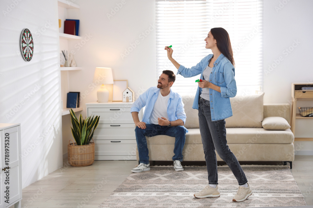 Fototapeta premium Man and woman playing darts at home