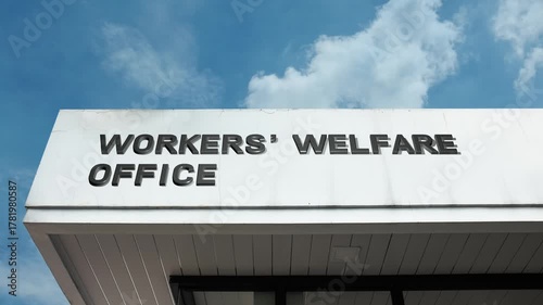 Worker's Welfare Office word sign displayed on a governmental or labor building under a clear blue sky, symbolizing employment rights, labor support, employee benefits, social security, and public