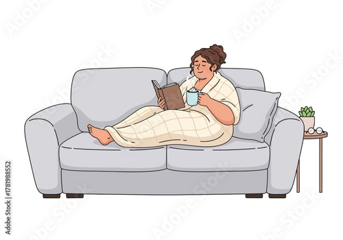 A relaxed woman enjoys reading a book and drinking a hot beverage while cozied up on a sofa with a blanket.