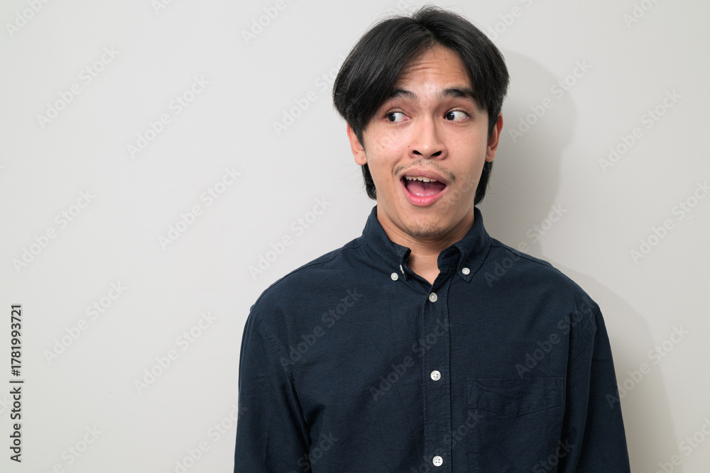 Fototapeta premium Portrait of handsome Young Asian Thai man surprised looking to side against white background