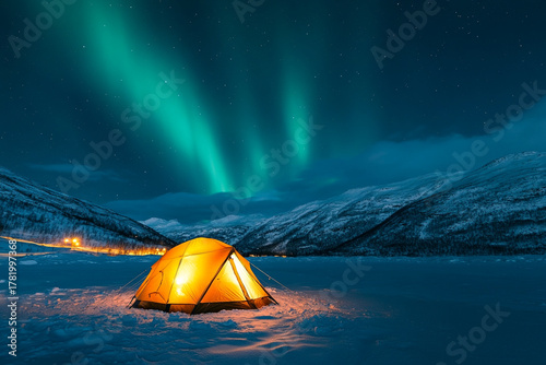 glowing tent in snowy landscape under the mesmerizing Northern Lights