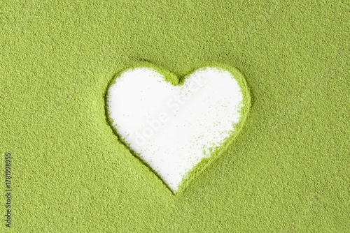 Creative mockup with heart-shaped cutout in vibrant green matcha powder on white background, suitable for natural-themed visual content