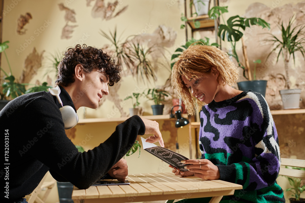 Fototapeta premium Stylish couple sharing ideas over coffee in a cozy cafe garden setting