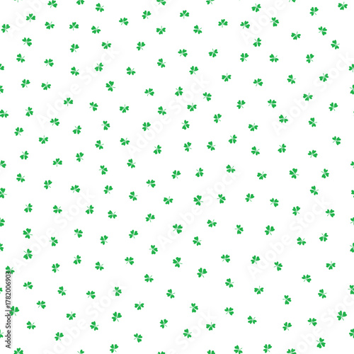 Ditzy green shamrocks seamless vector pattern background. Tossed three leaf clover on white backdrop. Irish lucky charm motifs. Scattered St. Patricks day symbols for celebration background.