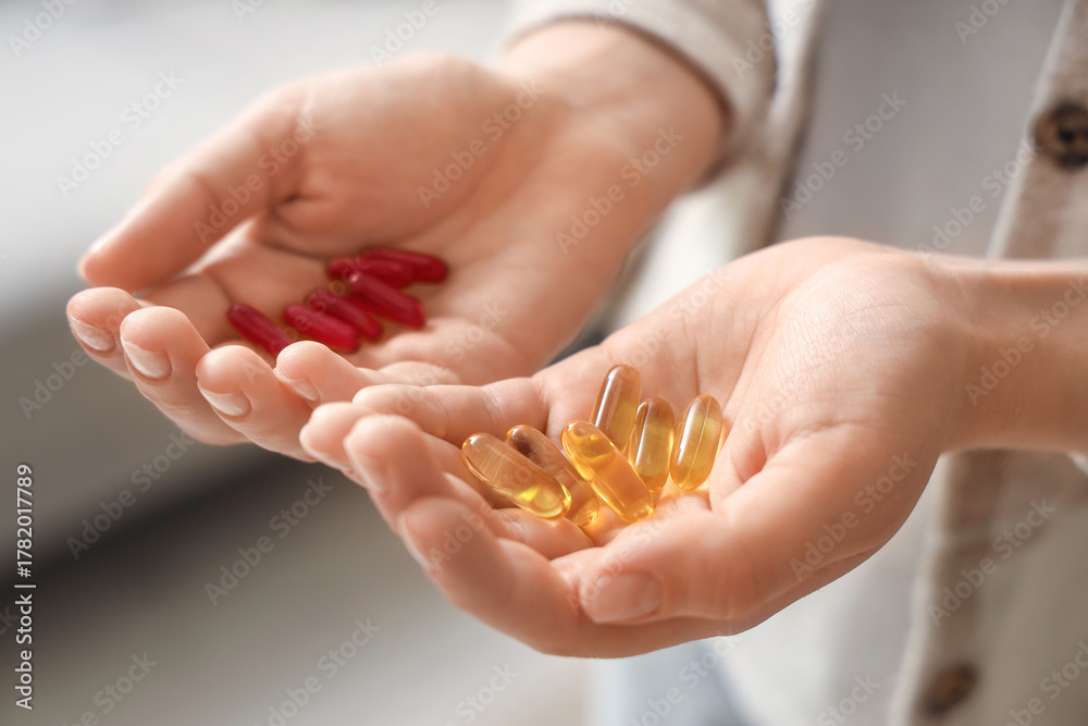Obraz premium Woman with vitamin E pills at home, closeup