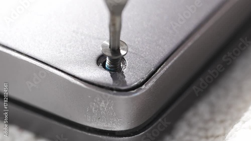 close up. screwdriver and screw. A technician disassembles a laptop.