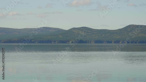 A mountain lake on a warm sunny day. The calm surface of the war. Summer vibe.
