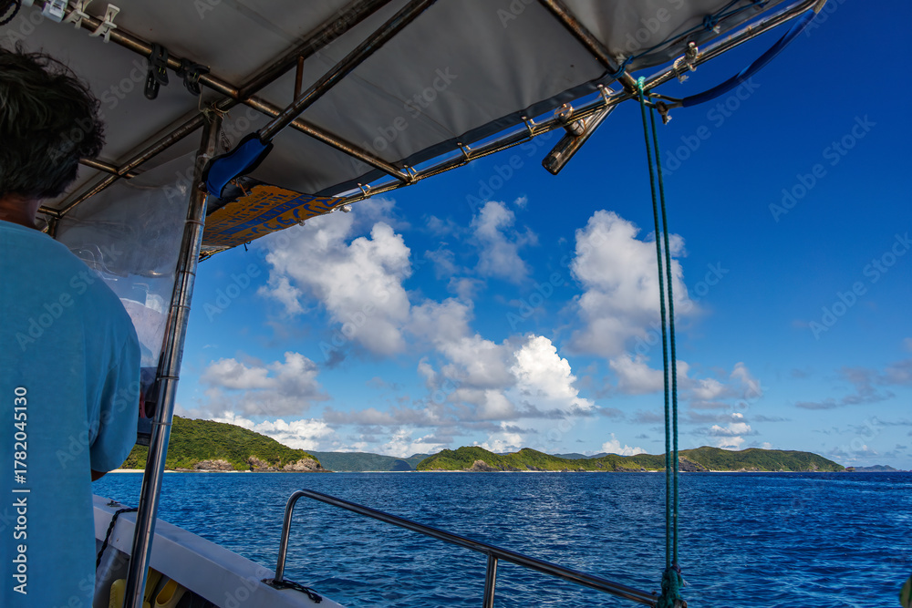 Obraz premium 座間味島無人島渡しの渡し船。 美しいサンゴ礁と熱帯魚の群れ。 安室島沖縄県 島尻郡慶良間諸島座間味島-2025 サンゴの産卵があり卵が漂う。沖縄本島から40km西方の諸島。30以上の島嶼群全体が国立公園に指定。珊瑚礁の青い海と白い砂浜は世界屈指の美。貴重な動植物が多数生息。 