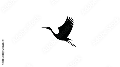 Minimalist black silhouette of a graceful flying crane bird, elegant wildlife symbol isolated on a clean white background.